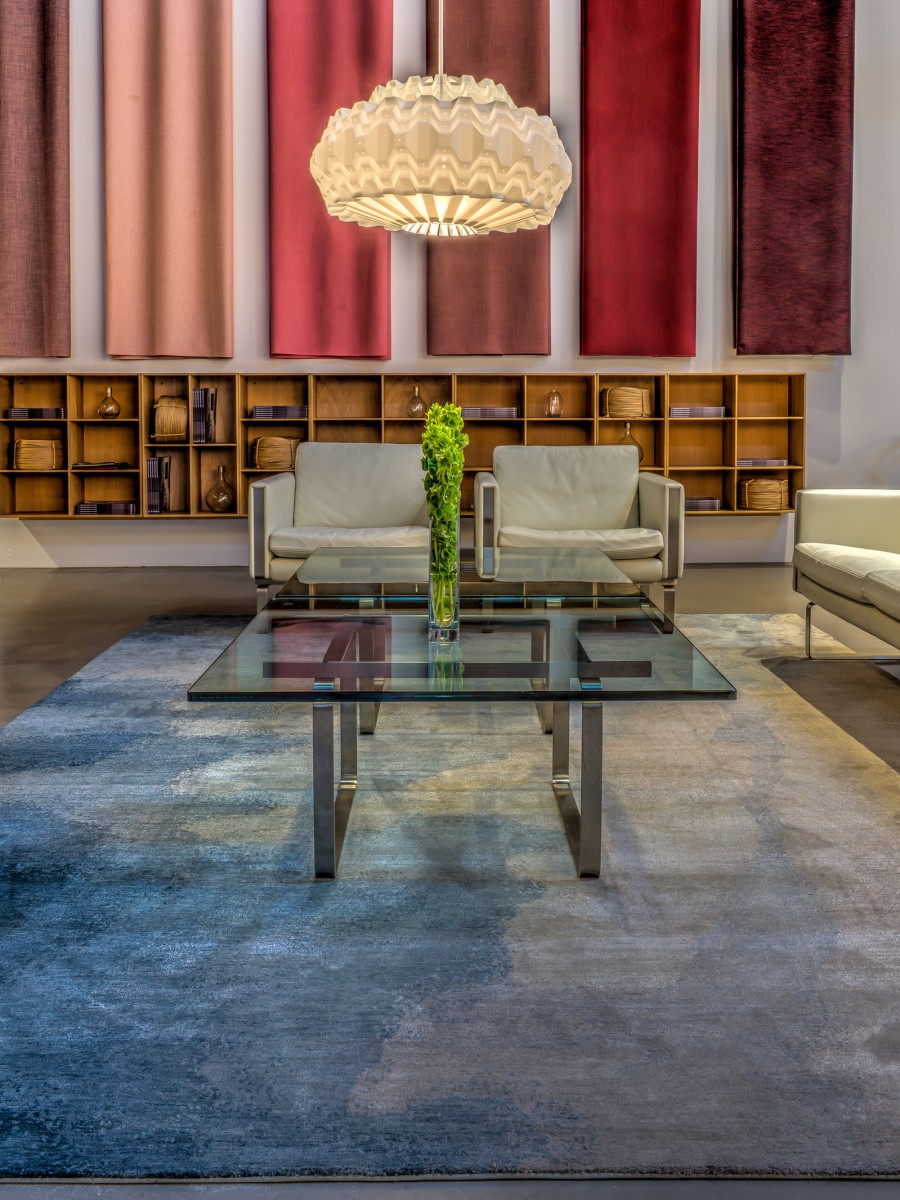 Nimbus rug displayed in hotel lobby with red curtains and white chairs